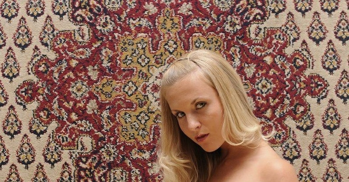 Кокетливая блондиночка развалившись на ковре зазывает трахаться