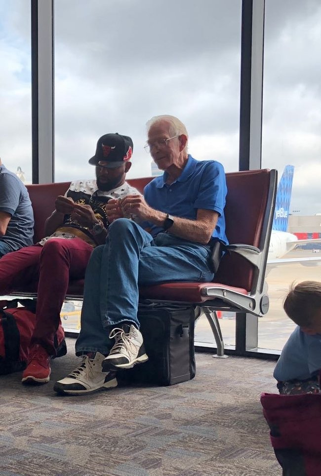 Elderly man teaches young man how to make dollar origami - The airport, Origami