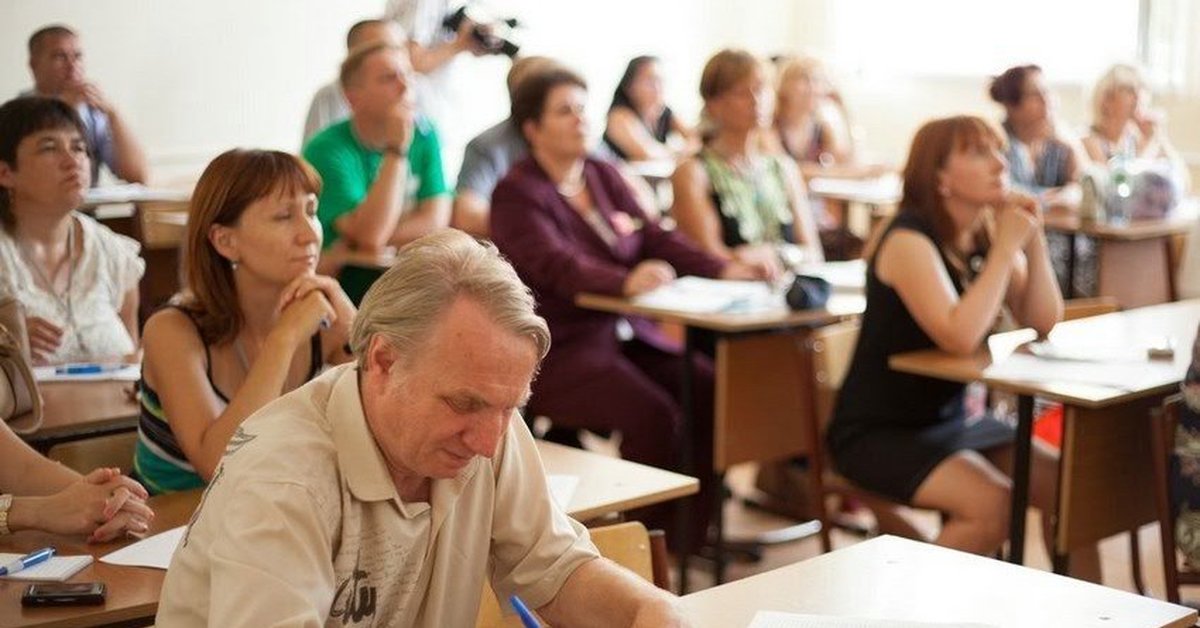 Тестирование учителей. Родители за партой. Взрослые за партой. Учитель за партой. Взрослые люди за партами.