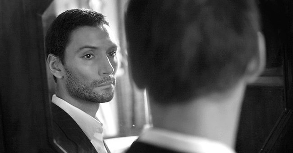 отражение мужчины в зеркале. парень в отражении. молодой человек прихорашивается перед зеркалом. мужчина в зеркале в полный рост. парень в костюме в зеркале.