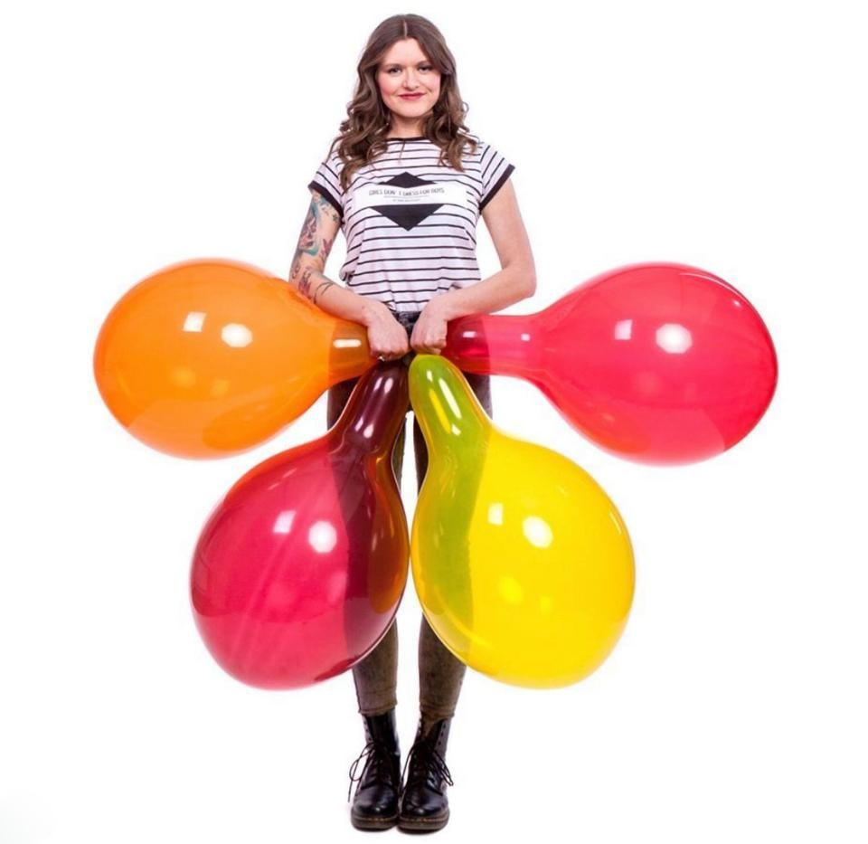 Стоковое видео категории «Премиум» — Девушка надувает воздушный шар перед зеленым экраном